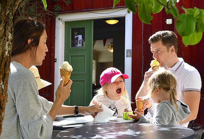 Bild på en familj som sitter och äter glass